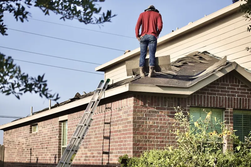 Professional roofer working on a residential roof in Roundtree